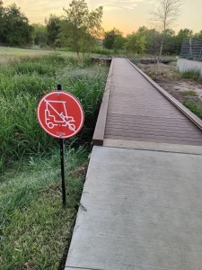 No golf cart sign near trail bridge at the Easton Park Dog Park and The Union